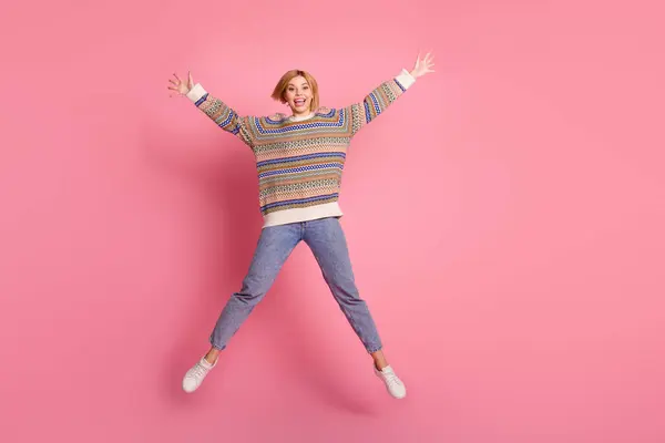 楽観的なエクスタシーな女の子の完全な長さの写真 プリントセータージーンズジャンプ ピンク色の背景に隔離された大きな販売を発表 — ストック写真