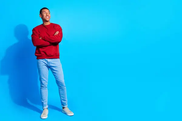Full body portrait of minded creative man crossed arms look empty space brainstorming isolated on blue color background.