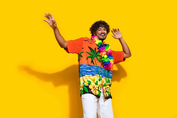 鮮やかな黄色の背景で隔離されたパーティーで踊るプリントシャツの花のネックレスを着た陽気な注意のない男の写真 — ストック写真