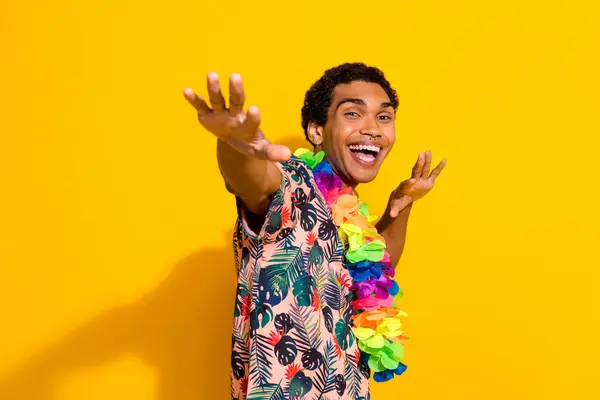 若いクレイジーな男の写真 ダンスはあなたに夏のパーティーで手を引きます 黄色の背景に隔離されたハワイスタイルの花のネックレス — ストック写真