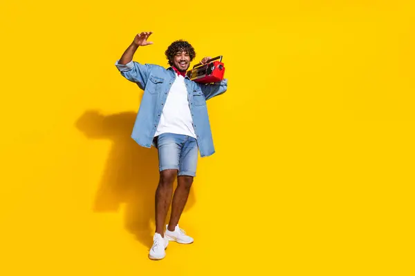 魅力的な若い男ブームボックス音楽のフルボディ写真 陽気なウェア トレンディなデニム服 黄色の背景に隔離された赤いスカーフ — ストック写真