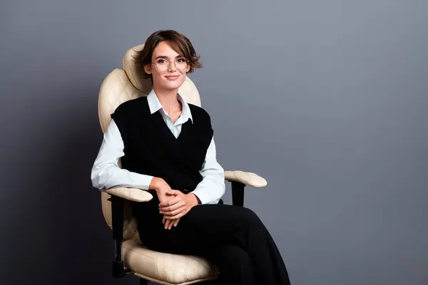 Фото Успешной Женщины Черном Жилете Очках Сидящей Кресле Офисе Изолированном — стоковое фото