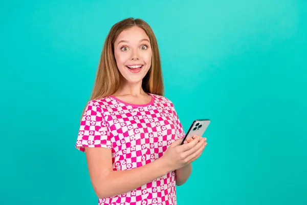 可爱少女手持装置的照片肖像兴奋的反应穿着时髦的印花粉色衣服隔离在青色背景下 — 图库照片