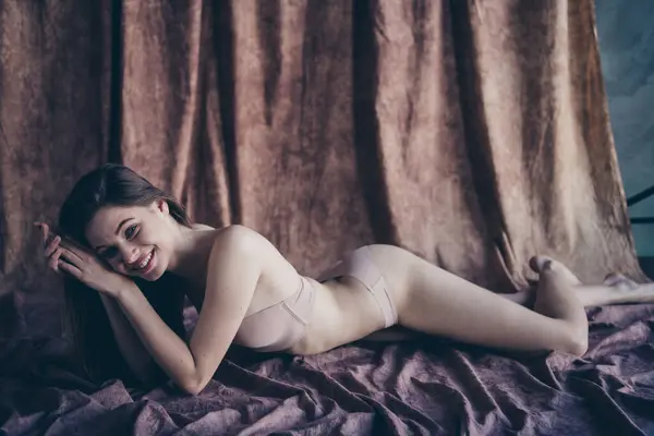 Photo no filter of tender stunning girl lying on silky linen textile enjoying her body isolated studio background.
