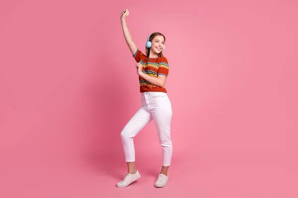 満喫した素敵な女の子の完全なボディ肖像画は 良い気分ダンスを聞くピンク色の背景に隔離された新しいプレイリストを持っています — ストック写真