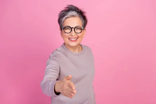 照片上快乐而成功的退休女性握手致意雇佣一位因粉红背景而离职的新工作 — 图库照片