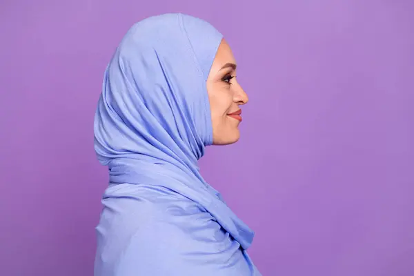 かわいい若い女性のプロフィール写真は紫色の背景に隔離された青いヒジャブを身に着けているアドラマダンの休日に見えます — ストック写真