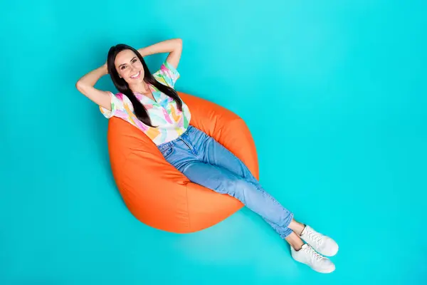 Photo of adorable lovely latin woman wear trendy print clothes hold arms behind head enjoy relax rest isolated on cyan color background.