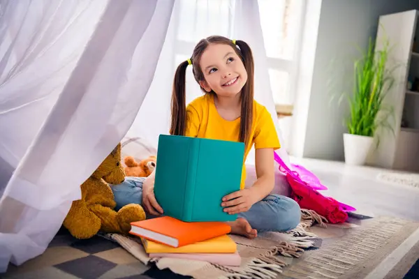 可爱小女孩的照片肖像读书帐篷看起来空荡荡的空间穿着时髦的黄色衣服幼儿园的内部 — 图库照片
