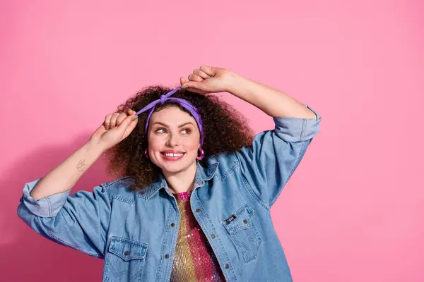 Photo of excited funky lady dressed denim outfit adjusting hairband emtpy space isolated pink color background.