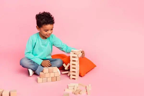 かわいい小さな男の子のフルボディ写真は ジャンガ木製のブロックゲームは ピンク色の背景に隔離されたトレンディなアクアマリン服を着用します — ストック写真