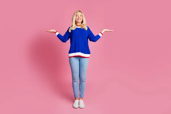 美しい女性の腕のフルサイズの写真は ピンク色の背景で隔離された青いセーターを着用空のスペースを示しています — ストック写真