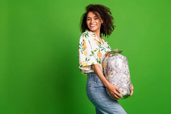 stock image Photo of positive good mood woman dressed print shirt collecting heavy money glass jar empty space isolated green color background.