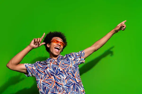 stock image Photo of funky impressed man dressed print shirt dark glasses dancing pointing two fingers empty space isolated green color background.