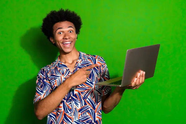 stock image Photo of excited funky man dressed print shirt pointing modern gadget empty space isolated green color background.