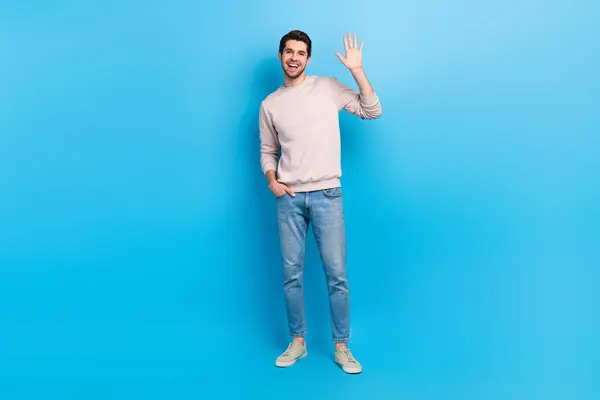 かなり興奮した男の完全な長さの写真 ベージュ スウェット シャツ振る腕の手のひら 孤立した青い色の背景 — ストック写真