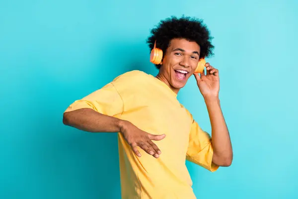 아프로 노란색 티셔츠와 남자의 청록색 배경에 헤드폰에 정력적인 음악을 — 스톡 사진