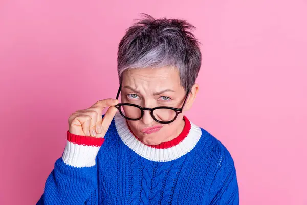 素敵な老婦人の写真 タッチ眼鏡 ピンク色の背景に隔離された青いセーターを着用すると思います — ストック写真