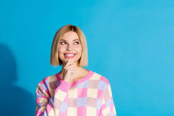 Portrait of minded girl with bob hair wear checkered pullover thoughtfully look at offer empty space isolated on blue color background.