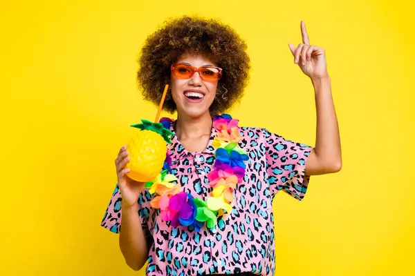 Photo of funky excited lady dressed leopard print shirt sunglass enjoying juice pointing empty space isolated yellow color background.