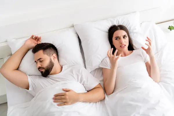 Photo of two people couple sleeping girl feel annoyed with snoring guy in house bed room.