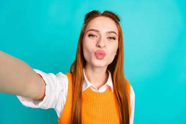 照片上漂亮姑娘的肖像自拍照片亲吻嘴唇穿着时髦的橙色针织衫 背景是青色的 — 图库照片