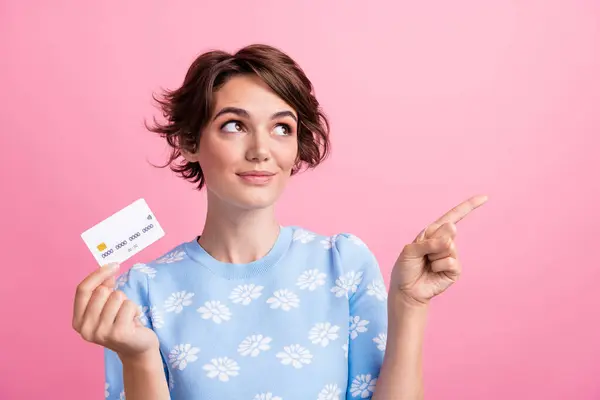 stock image Portrait of attractive lady hold debit card look direct finger empty space isolated on pink color background.