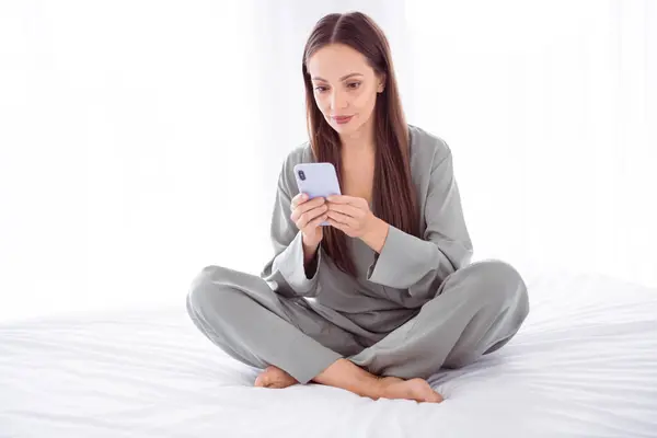 Photo Shiny Positive Lady Grey Sleepwear Typing Messages Apple Samsung — Stock Photo, Image