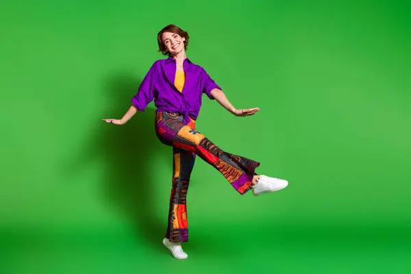 stock image Photo portrait of funny young woman in purple stylish shirt and brown bob haircut dancing likes freedom isolated on green color background.