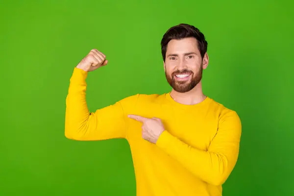 stock image Photo portrait of handsome young guy point show biceps muscle dressed stylish yellow garment isolated on green color background.