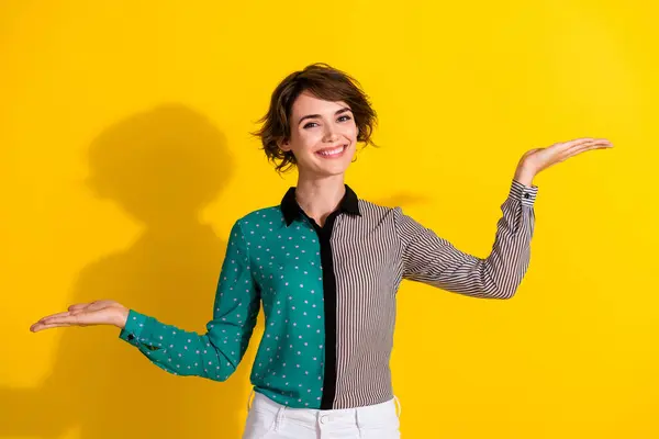 stock image Photo of lovely woman wear stylish dotted print clothes demonstrates empty space isolated on yellow color background.