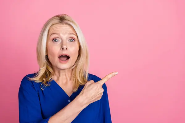 stock image Photo portrait of pretty senior female point shocked empty space wear trendy blue outfit isolated on pink color background.