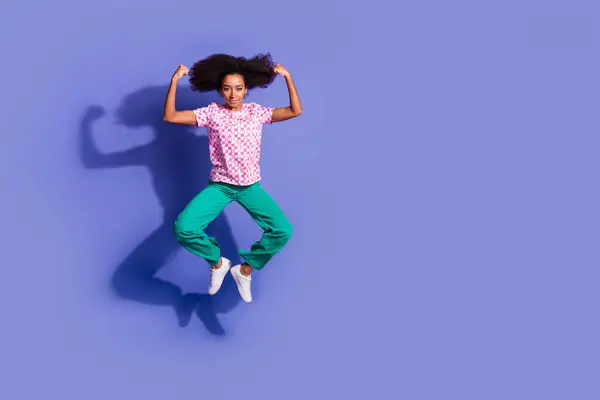 stock image Full length photo of lovely young lady jump flexing muscles dressed stylish pink garment isolated on violet color background.