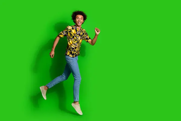 stock image Photo of cheerful positive glad man wear trendy summer print clothes walk empty space isolated on green color background.