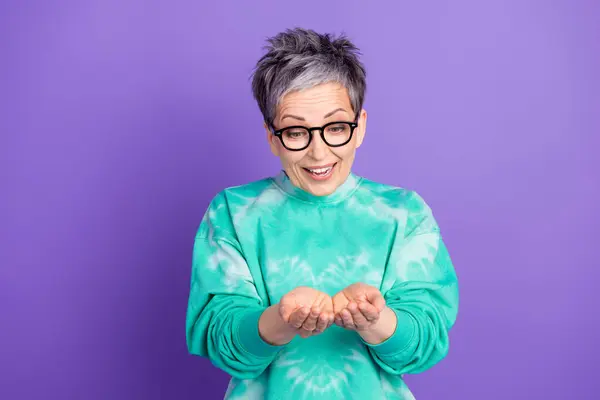 stock image Photo portrait of lovely pensioner lady hold excited empty space dressed stylish green garment isolated on purple color background.