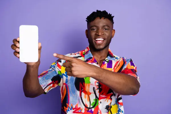 stock image Photo of handsome young guy hold device show point device white screen dressed stylish colorful garment isolated on purple color background.