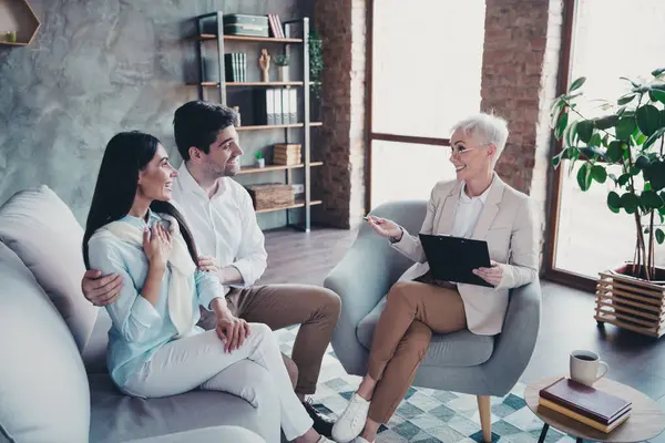 stock image Photo of young couple sit sofa cuddle appointment psychotherapist loft interior office indoors.