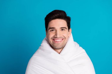 Photo portrait of attractive young man cheerful smile wrapped duvet dressed pajama sleepover good night isolated on blue color background. clipart