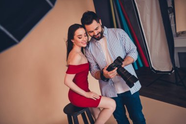 Fashion photographer making photo of young woman in sexy dress photosession in modern studio indoors. clipart