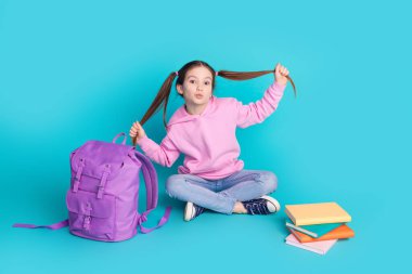 Full length photo of lovely little girl pull tails school sales kiss dressed stylish pink garment isolated on aquamarine color background. clipart