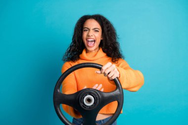 Photo of pretty young girl hold wheel beep horn wear orange pullover isolated on teal color background. clipart