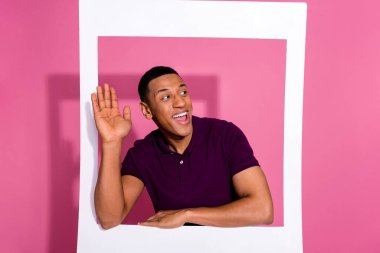 Photo of attractive young man look wave empty space instant photo frame dressed stylish violet clothes isolated on pink color background. clipart