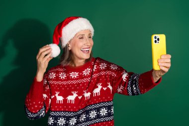 Photo of cheerful holly jolly woman wear stylish clothes hold device take selfie isolated on green color background. clipart