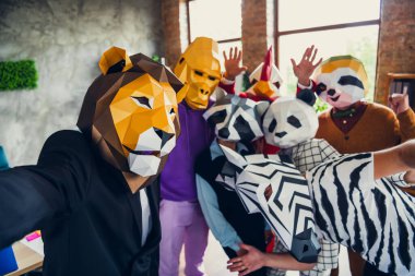 Portrait of panda rooster gorilla lion sloth zebra raccoon mask business people take selfie loft business center indoors. clipart