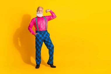 Full body photo of retired man flexing muscles dressed pink shirt vintage plaid pants fancy clothes isolated on yellow color background. clipart