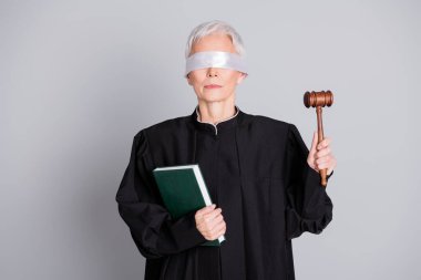 Photo of old woman judge with closed eyes hold book raise gavel isolated grey color background. clipart