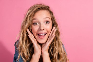 Charming young woman with blonde hair in casual denim poses with a joyful expression against a pink backdrop, radiating youthful fashion and cheerfulness, ideal for lifestyle and promotional imagery. clipart