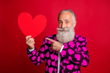 Photo of funky mature man cupid amour hold big paper heart shape indicating finger creative postcard wear stylish hearts pattern suit blazer shirt tie isolated red color background clipart