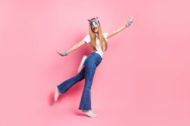 A cheerful girl striking a playful pose in casual attire, adorned with an animal-themed mask, in front of a vibrant pink background. clipart