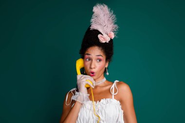 A young woman in classic fashion poses with a telephone, merging historical elegance with modern style. Vibrant green backdrop enhances her glamorous appearance. clipart